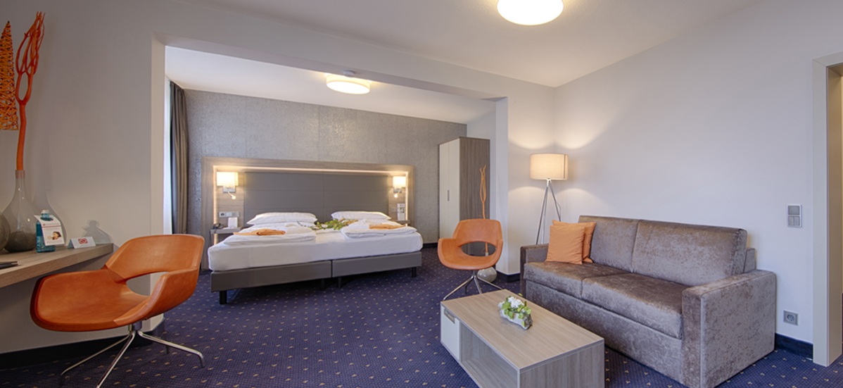 Junior Suite mit Bett, Sofaecke und Schreibtisch im Best Western Plus Hotel Steinsgarten, Gießen