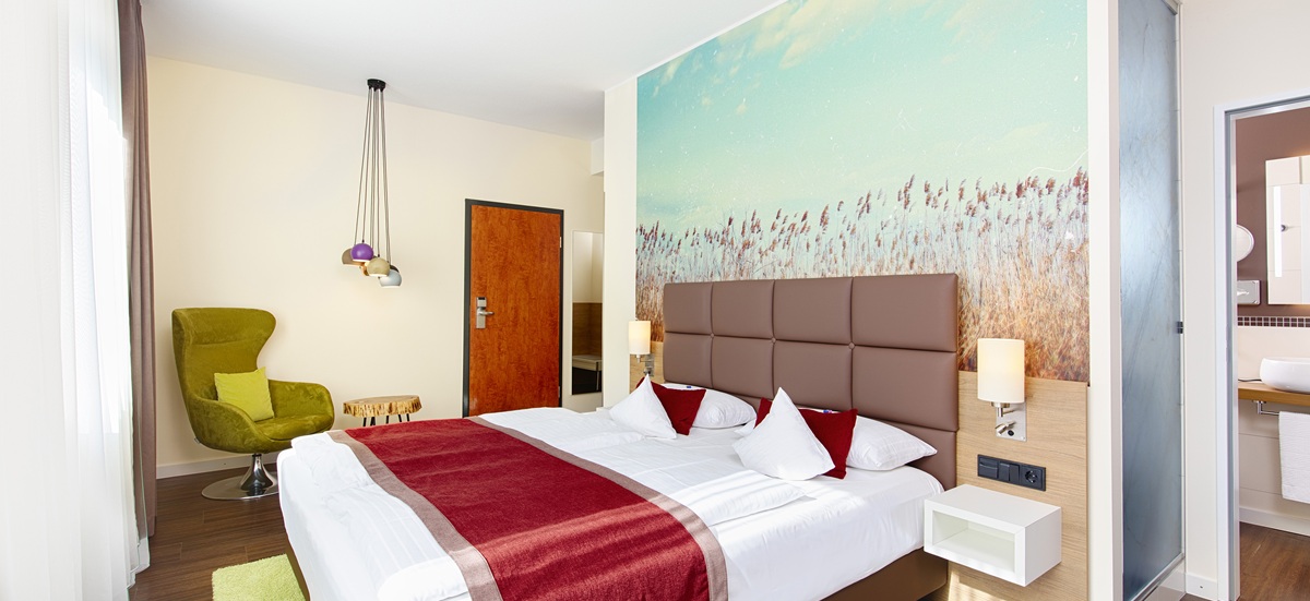 Zimmerbild  mit Bett, Fototapete und modernen Lampen im Best Western Hotel Hohenzollern 